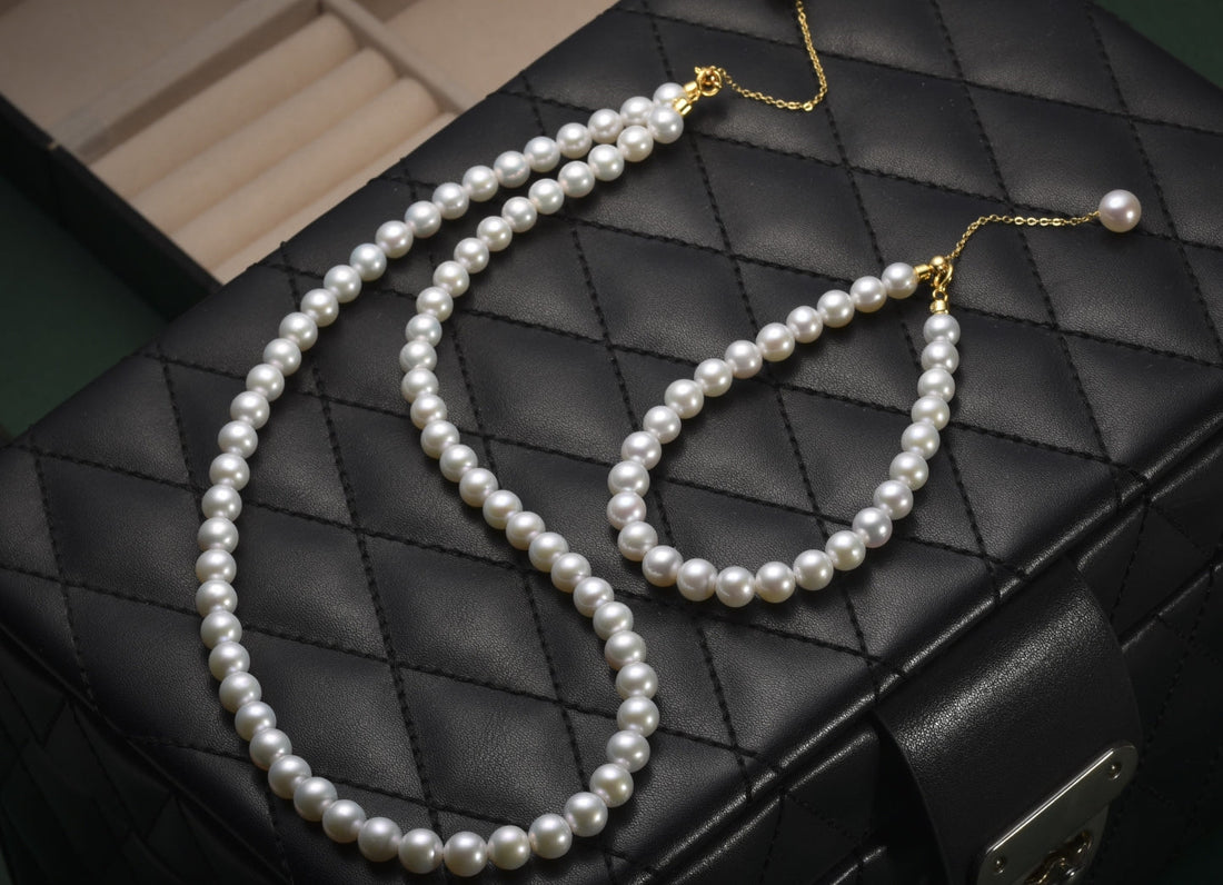Timeless Pearl's elegant Akoya-style necklace and bracelet set on a black quilted case.