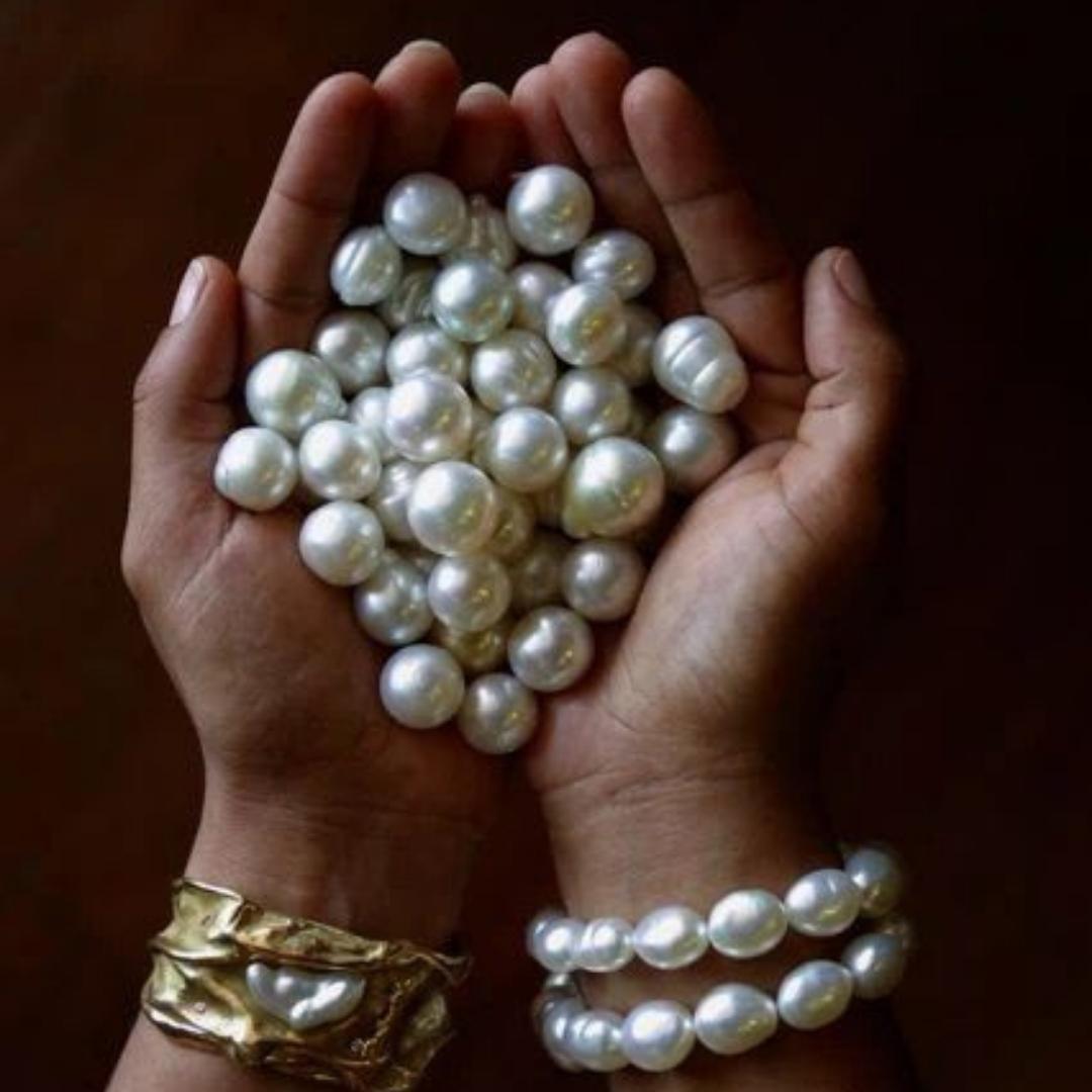 Hands full of radiant pearls, styled with Timeless Pearl’s bold and elegant jewelry pieces.