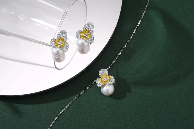 A Timeless Pearl earring and necklace set with golden and silver pearls placed delicately.