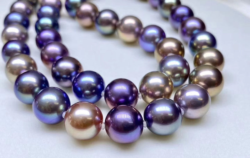 A close-up of a vibrant Timeless Pearl necklace featuring large, multicolored Edison pearls.