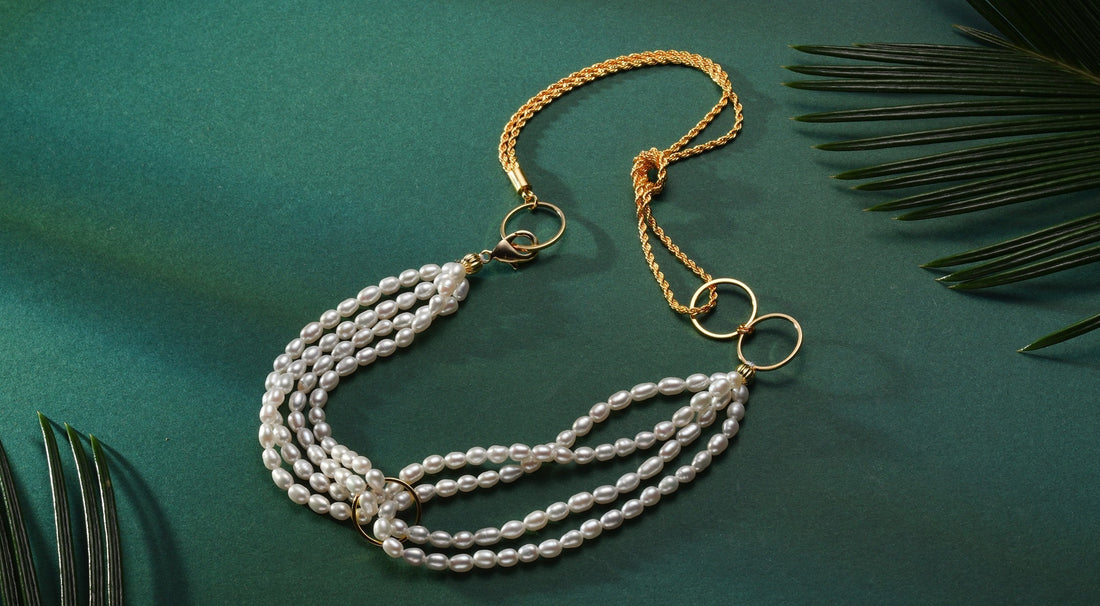 A Timeless Pearl necklace with several pearl loops and a gold chain placed.