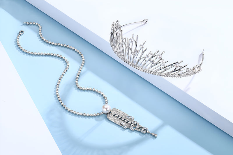 A Timeless Pearl necklace lying beside a sterling silver and pearl crown.