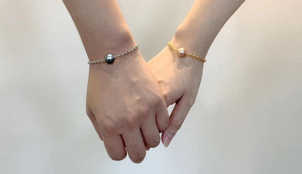 Timeless pearl bracelets being worn by two hands held together.