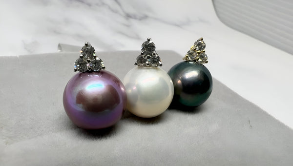 Three elegant pearl earrings in purple, white, and black tones from Timeless Pearl.