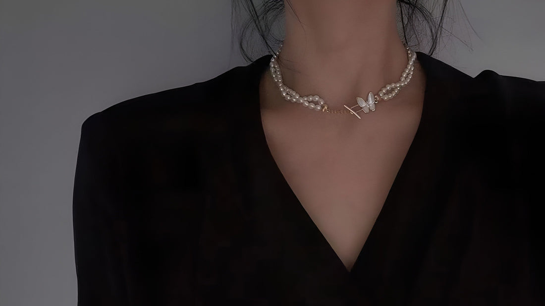 Woman wearing a butterfly pearl choker necklace from Timeless Pearl with an elegant black outfit.