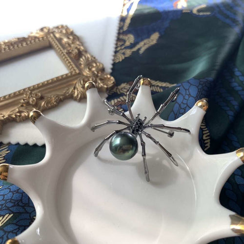 A spider figurine with a dark pearl body by Timeless Pearls