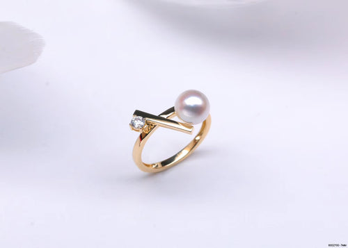 Gold ring with a large freshwater pearl and a diamond-like accent, featuring a modern geometric design