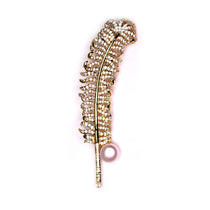 Golden feather-inspired brooch featuring delicate pearls for a sophisticated, natural look.