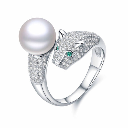 Silver ring featuring a panther-shaped design with diamond pavé and emerald eyes, complemented by a large white freshwater pearl