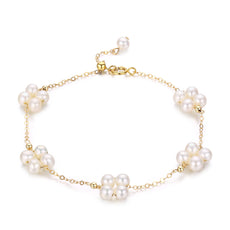 Delicate pearl bracelet with gold clover charm, perfect for layered styling.