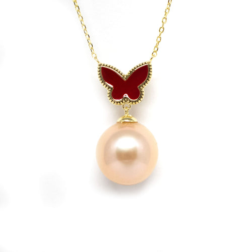 Gold necklace with a red enamel butterfly pendant and a large pink freshwater pearl drop